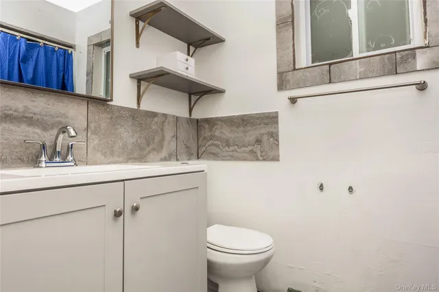 a bathroom with a toilet sink and mirror