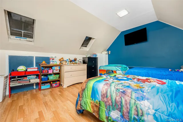 a bedroom with bed and a wooden floor