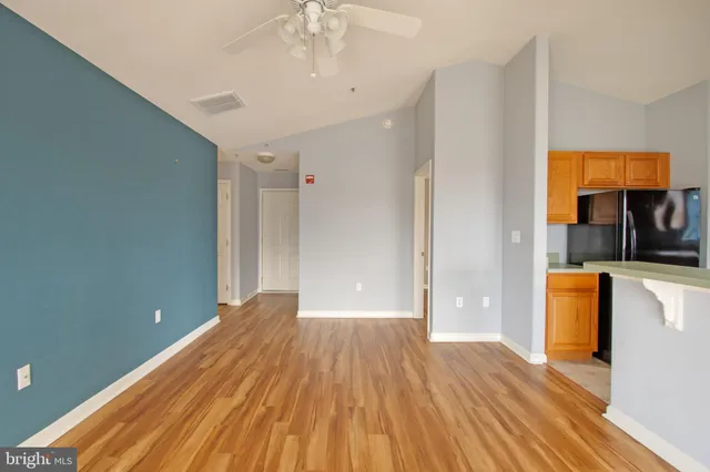 a view of a room with wooden floor and a ceiling fan