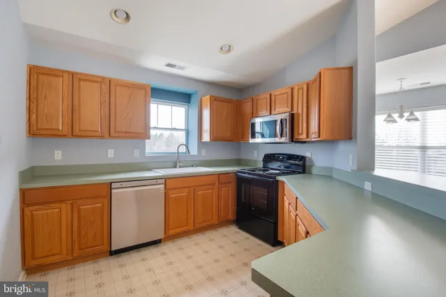 a kitchen with stainless steel appliances granite countertop a sink stove and microwave
