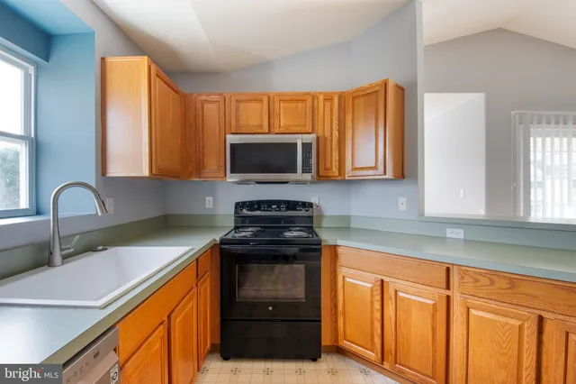 a kitchen with stainless steel appliances granite countertop a sink stove and microwave