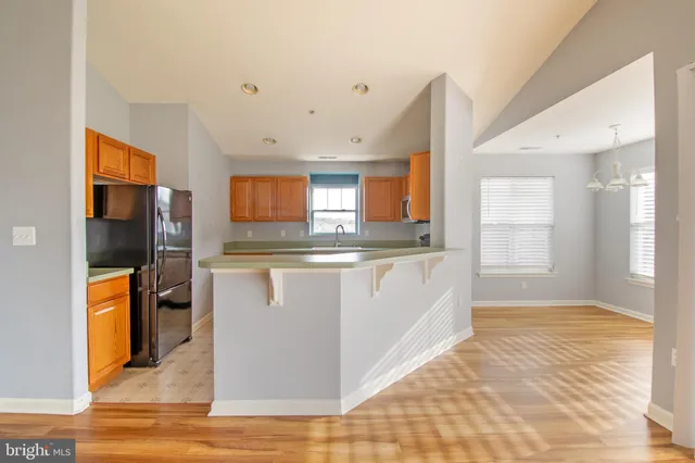 a kitchen with stainless steel appliances granite countertop a refrigerator a stove and a sink
