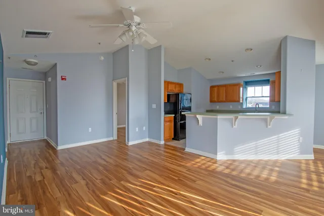 a view of a kitchen with kitchen island wooden floor center island and stainless steel appliances