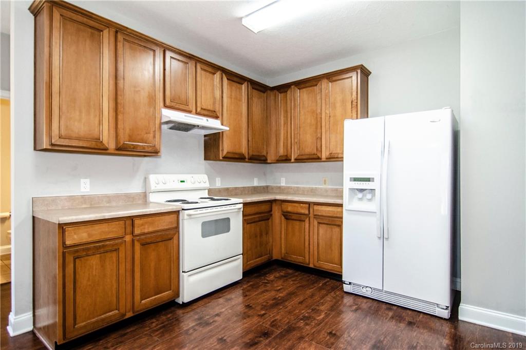 14232 Luscombe Farm Road Charlotte, NC 28278 - Photo 11 of 29 a kitchen with stainless steel appliances granite countertop a refrigerator a sink dishwasher and wooden cabinets with wooden floor