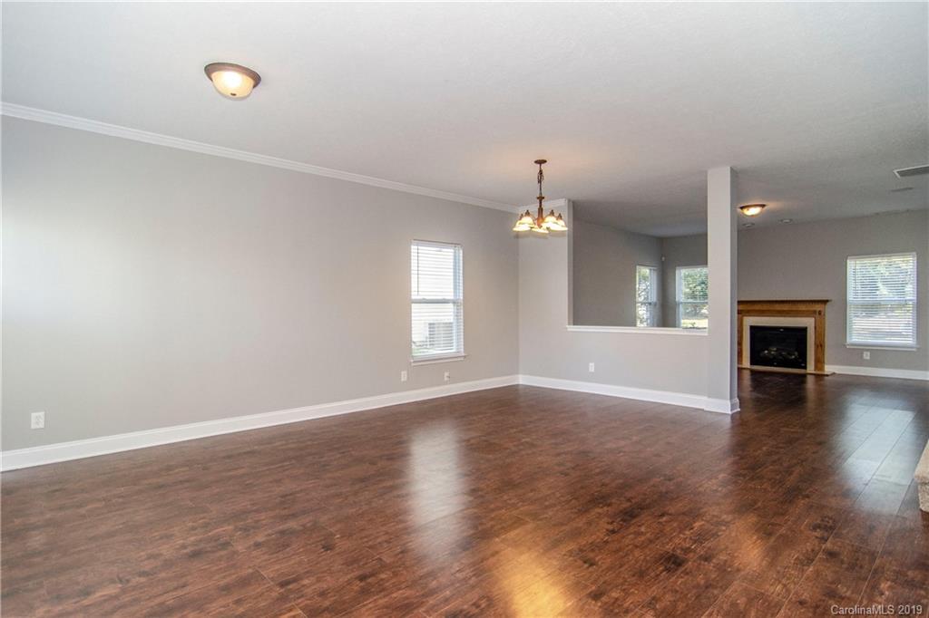 14232 Luscombe Farm Road Charlotte, NC 28278 - Photo 4 of 29 an empty room with wooden floor fan and windows