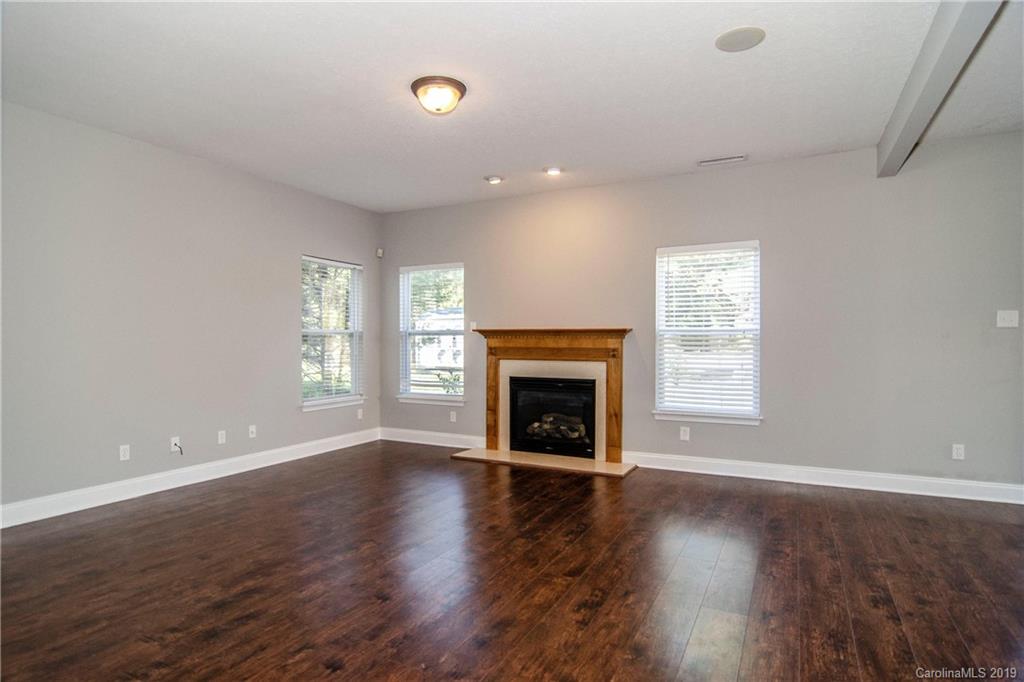 14232 Luscombe Farm Road Charlotte, NC 28278 - Photo 8 of 29 an empty room with wooden floor fireplace and windows