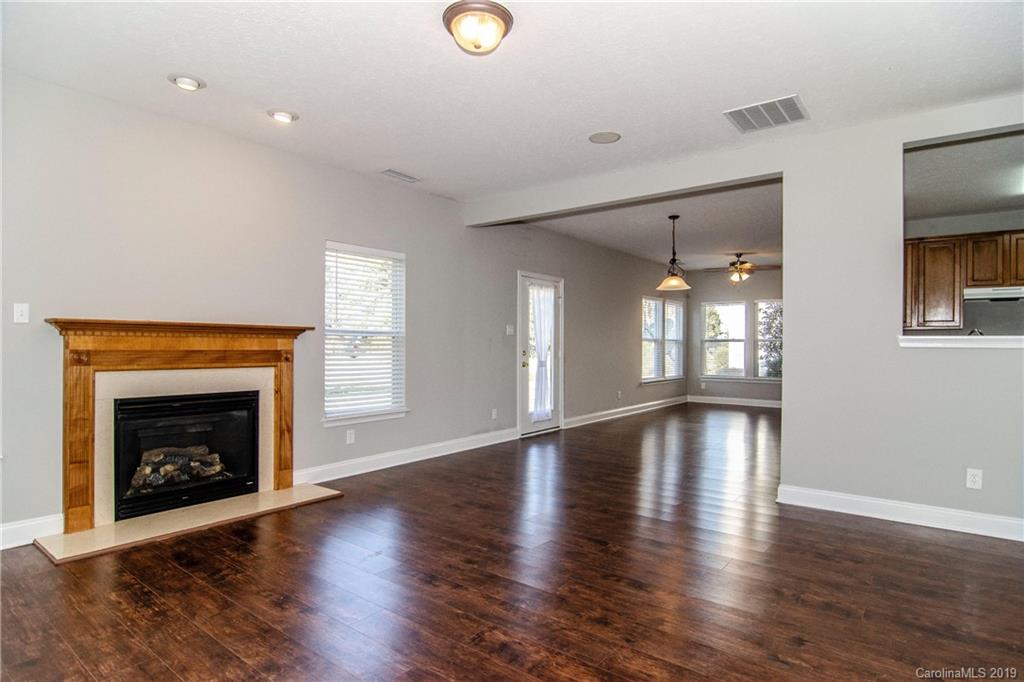 14232 Luscombe Farm Road Charlotte, NC 28278 - Photo 9 of 29 a view of an empty room with wooden floor fireplace and a window