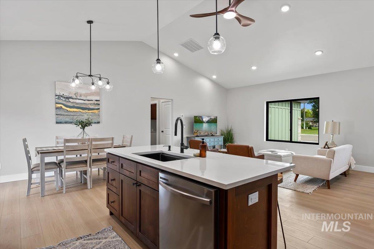 1201 Jade Drive Rupert, ID 83350 - Photo 14 of 27 Open-concept living space featuring a central kitchen island with a dark wood-finish base, integrated stainless steel dishwasher, and a white countertop