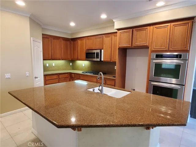 a kitchen with kitchen island a sink stainless steel appliances and cabinets