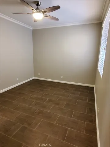 en empty room with a window and ceiling fan