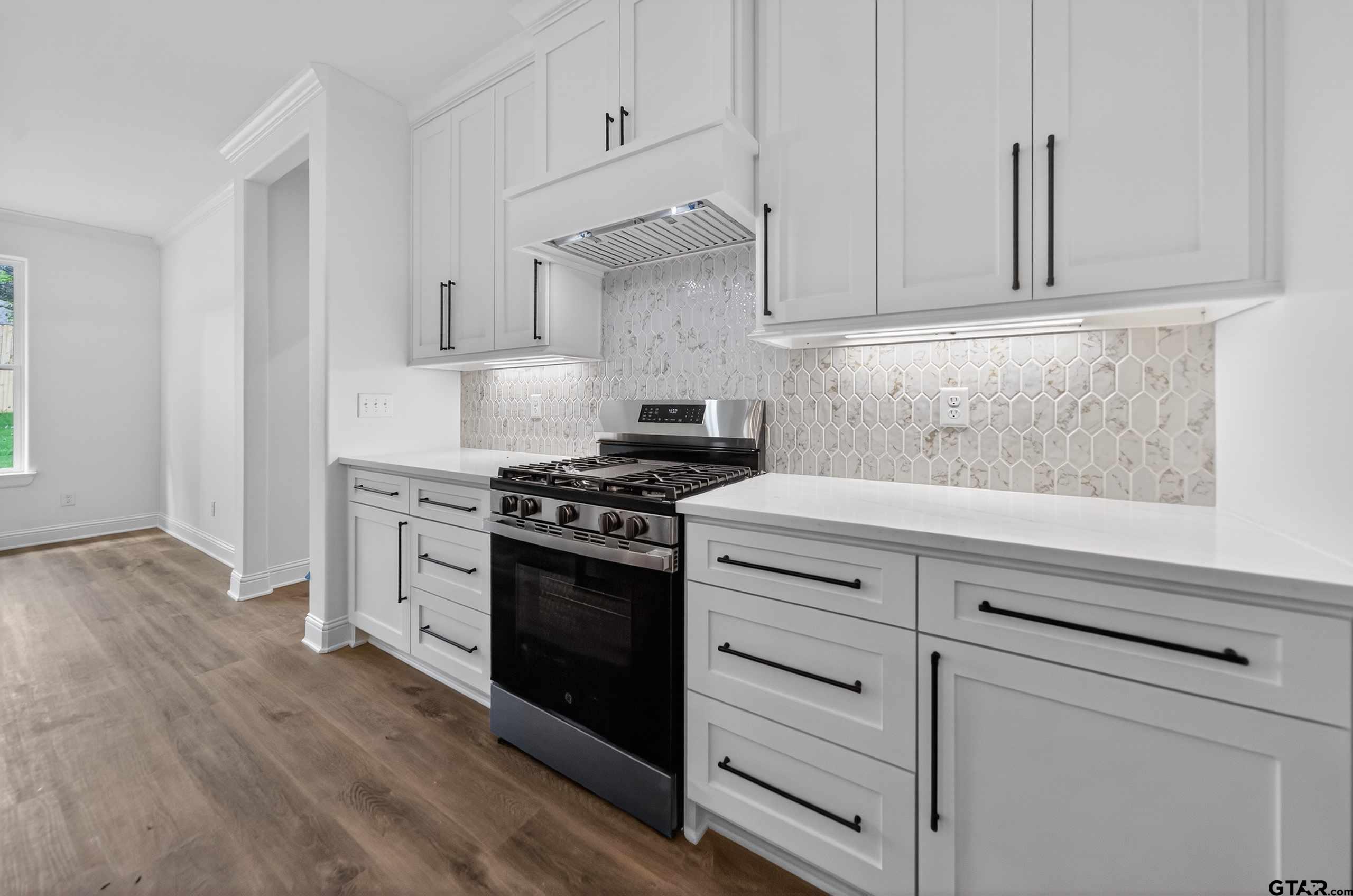 3045 Guinn Farms Road Tyler, TX 75707 - Photo 11 of 45 a kitchen with granite countertop white cabinets and appliances
