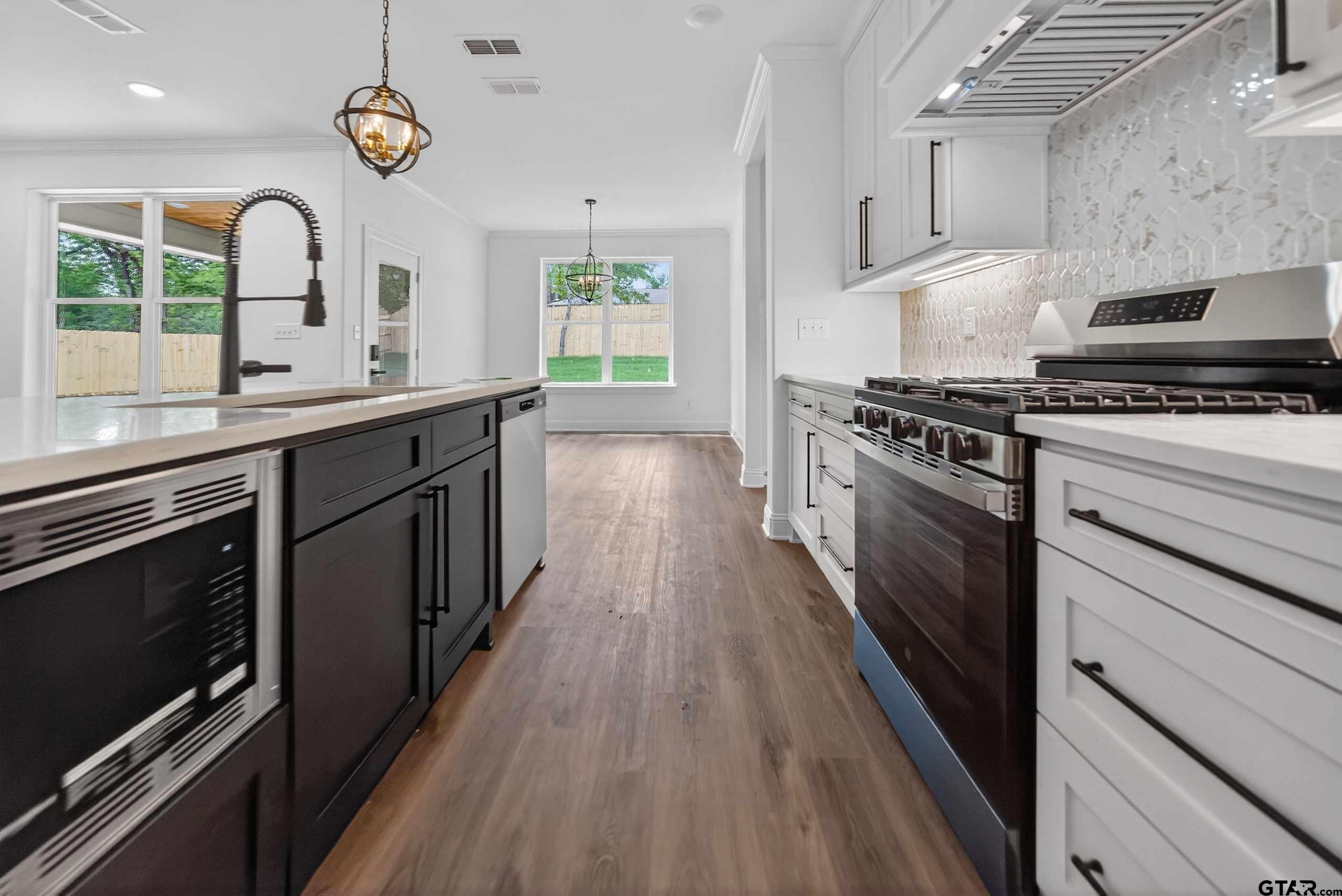 3045 Guinn Farms Road Tyler, TX 75707 - Photo 12 of 45 a kitchen with stainless steel appliances granite countertop a stove and a sink