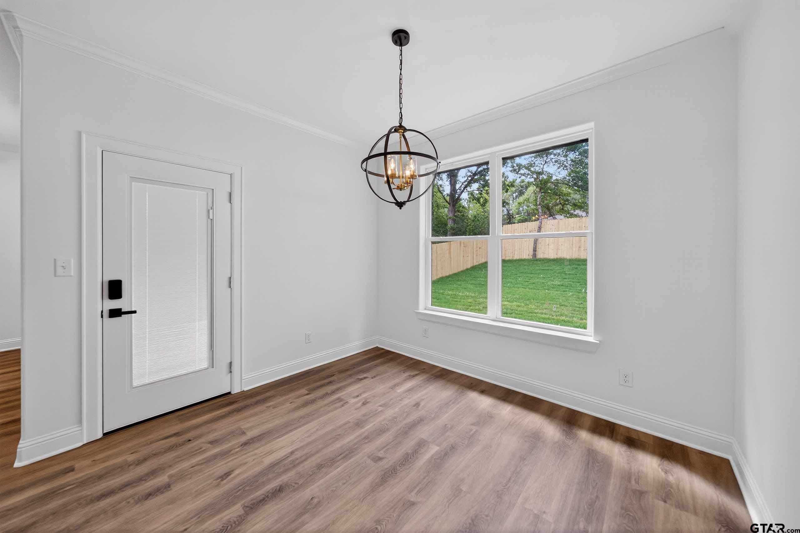 3045 Guinn Farms Road Tyler, TX 75707 - Photo 13 of 45 a view of a room with wooden floor exposed radiator and windows