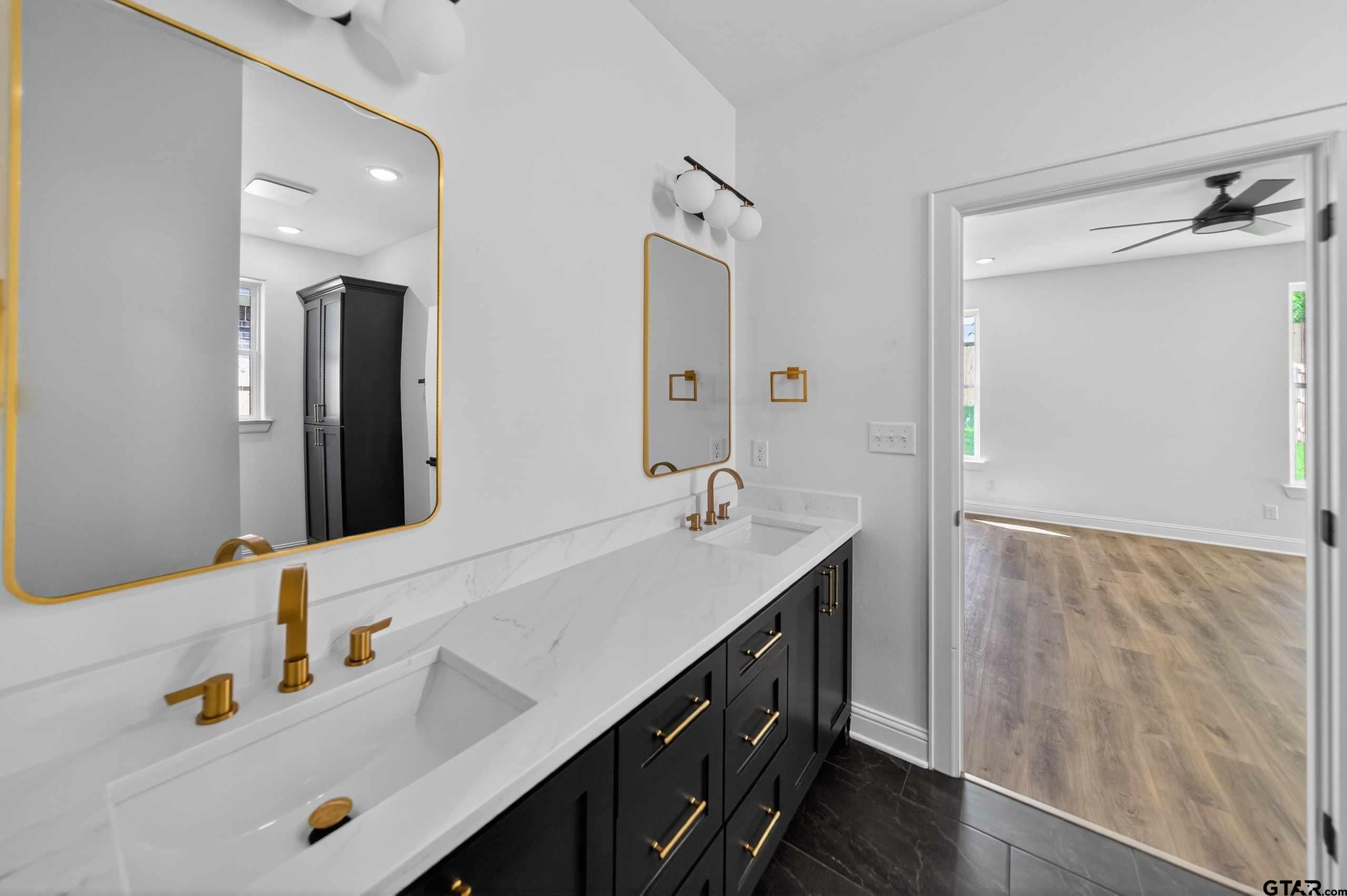3045 Guinn Farms Road Tyler, TX 75707 - Photo 21 of 45 a bathroom with a double vanity sink and a mirror