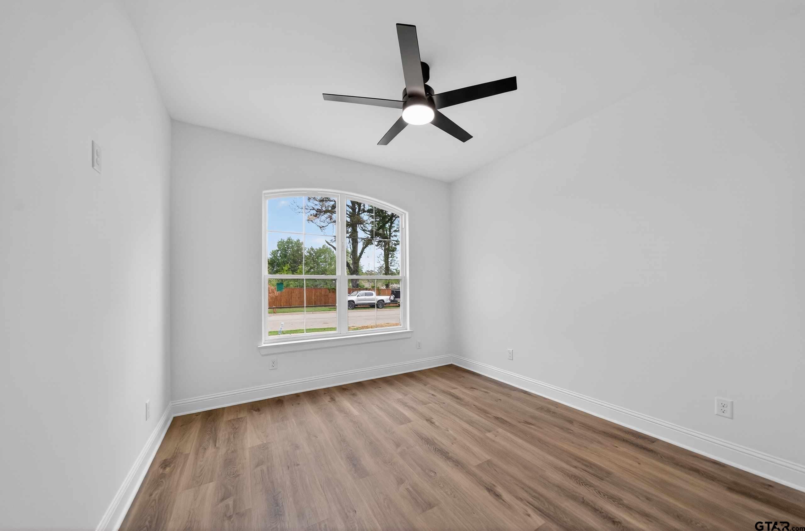 3045 Guinn Farms Road Tyler, TX 75707 - Photo 27 of 45 an empty room with wooden floor ceiling fan and window