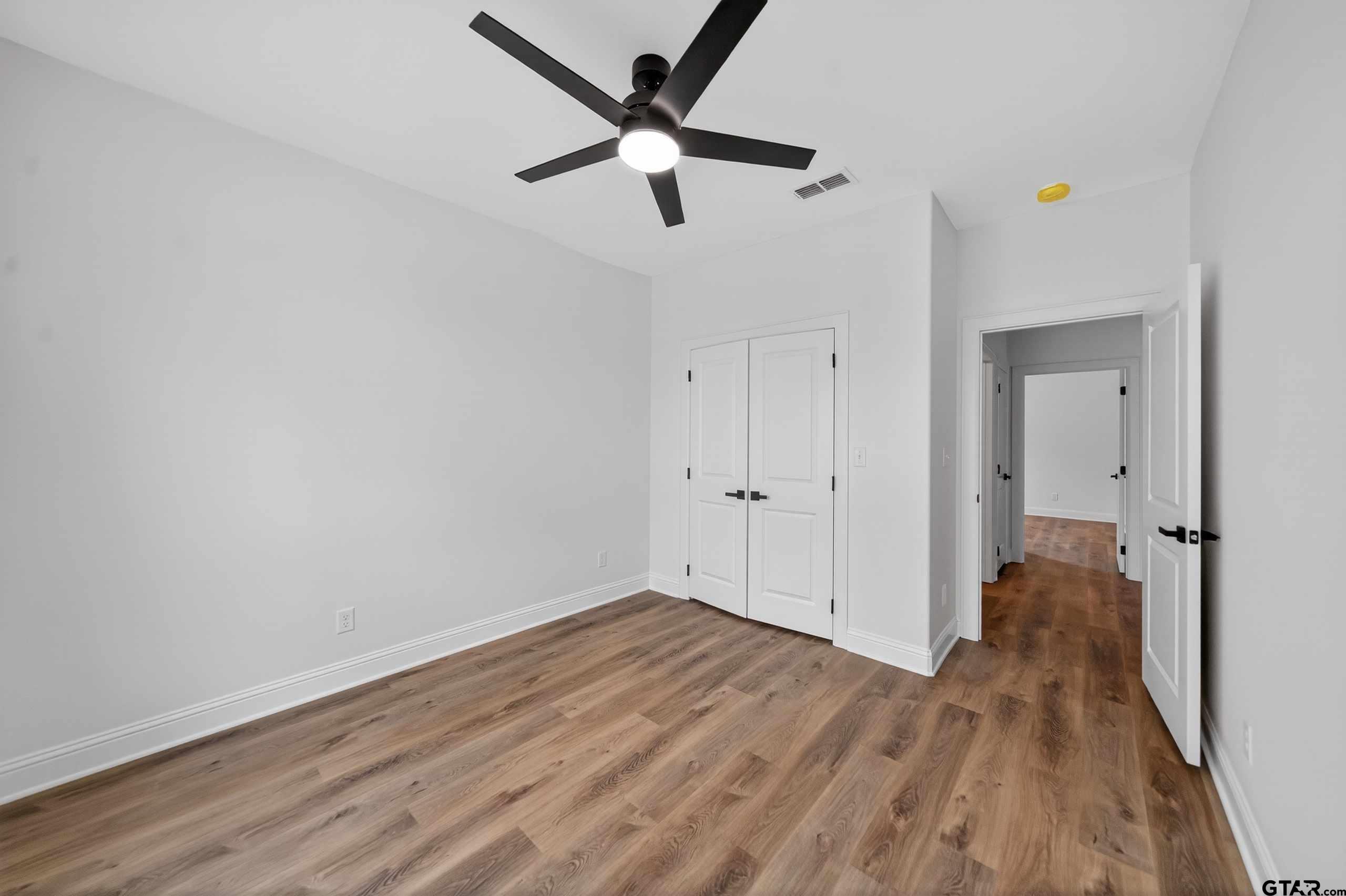 3045 Guinn Farms Road Tyler, TX 75707 - Photo 29 of 45 a view of a room with wooden floor a ceiling fan