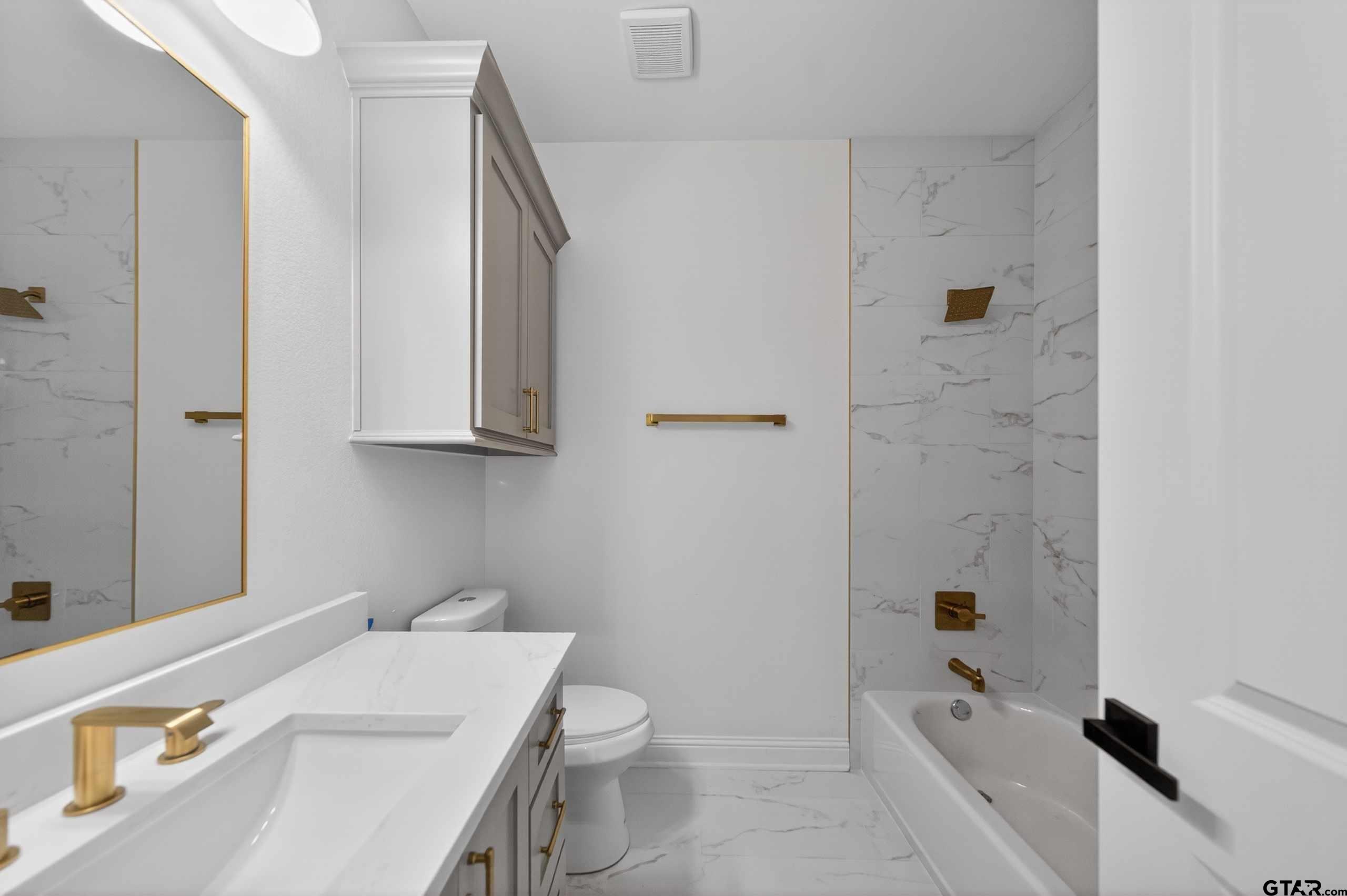 3045 Guinn Farms Road Tyler, TX 75707 - Photo 32 of 45 a bathroom with a sink a toilet and shower