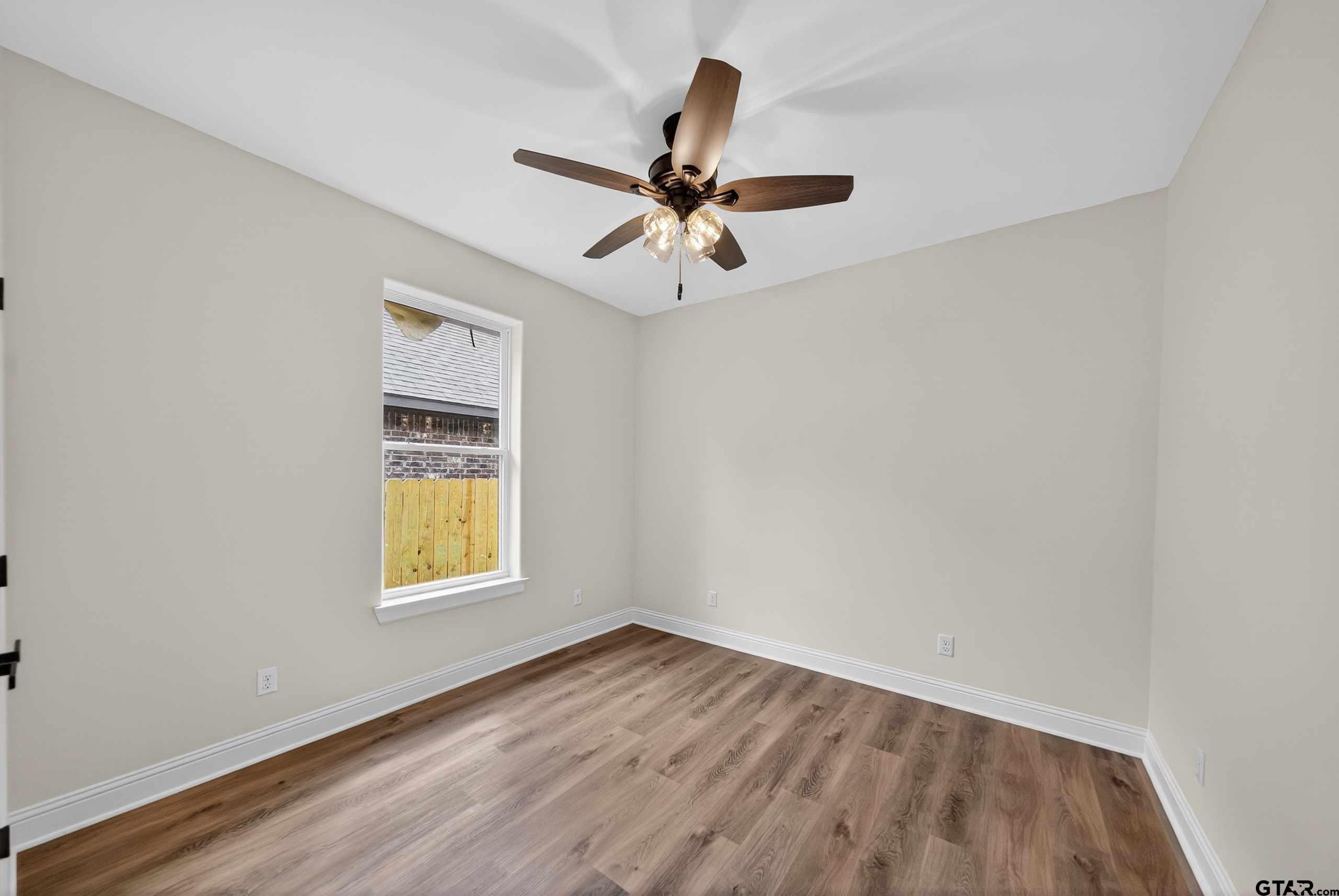 3045 Guinn Farms Road Tyler, TX 75707 - Photo 33 of 45 an empty room with a window and a ceiling fan