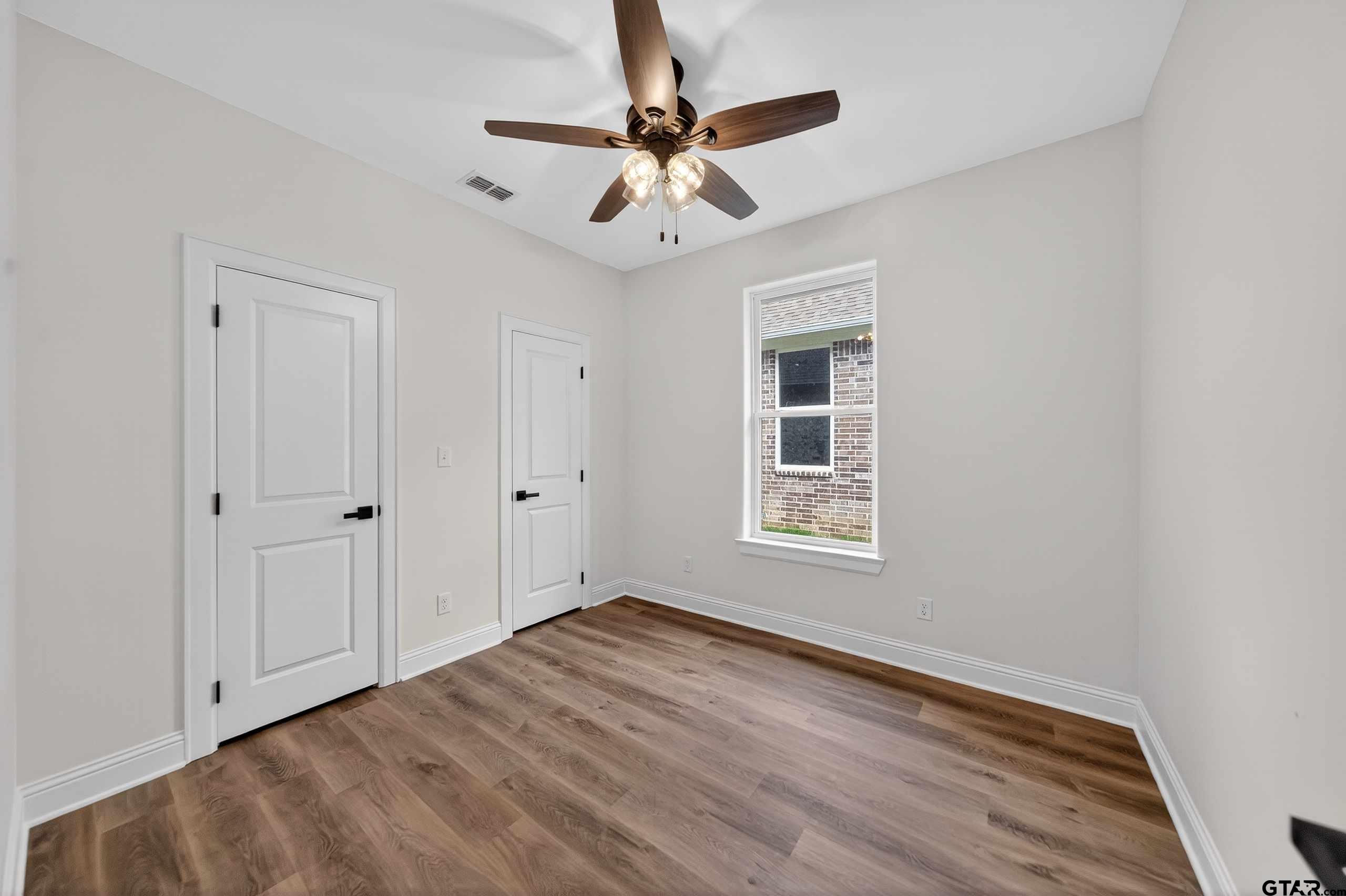 3045 Guinn Farms Road Tyler, TX 75707 - Photo 40 of 45 a view of an empty room with a window and wooden floor