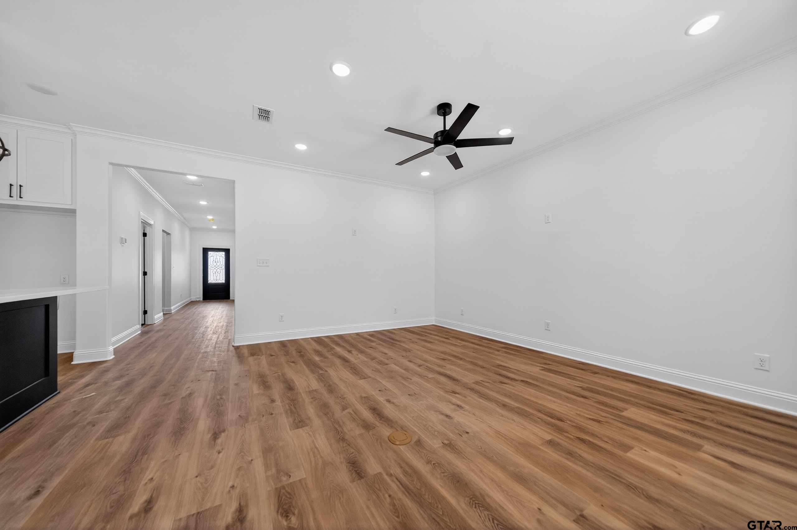 3045 Guinn Farms Road Tyler, TX 75707 - Photo 8 of 45 a view of a room with wooden floor and a ceiling fan