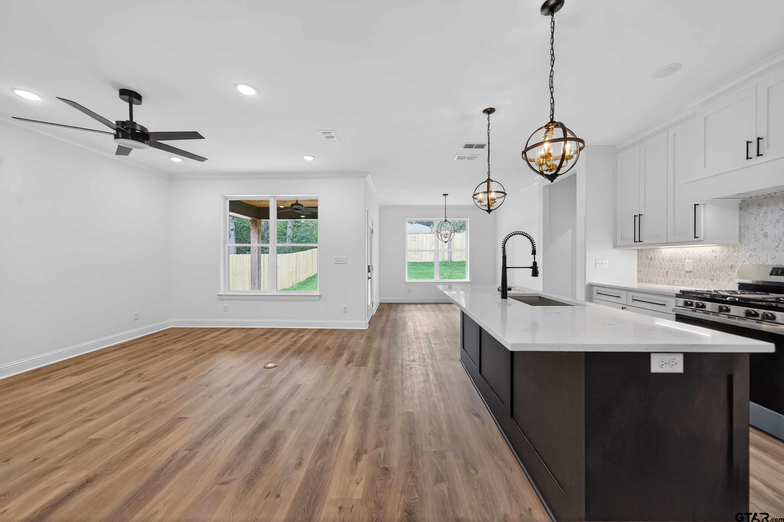3045 Guinn Farms Road Tyler, TX 75707 - Photo 9 of 45 a kitchen with stainless steel appliances granite countertop a stove a sink and a wooden floor