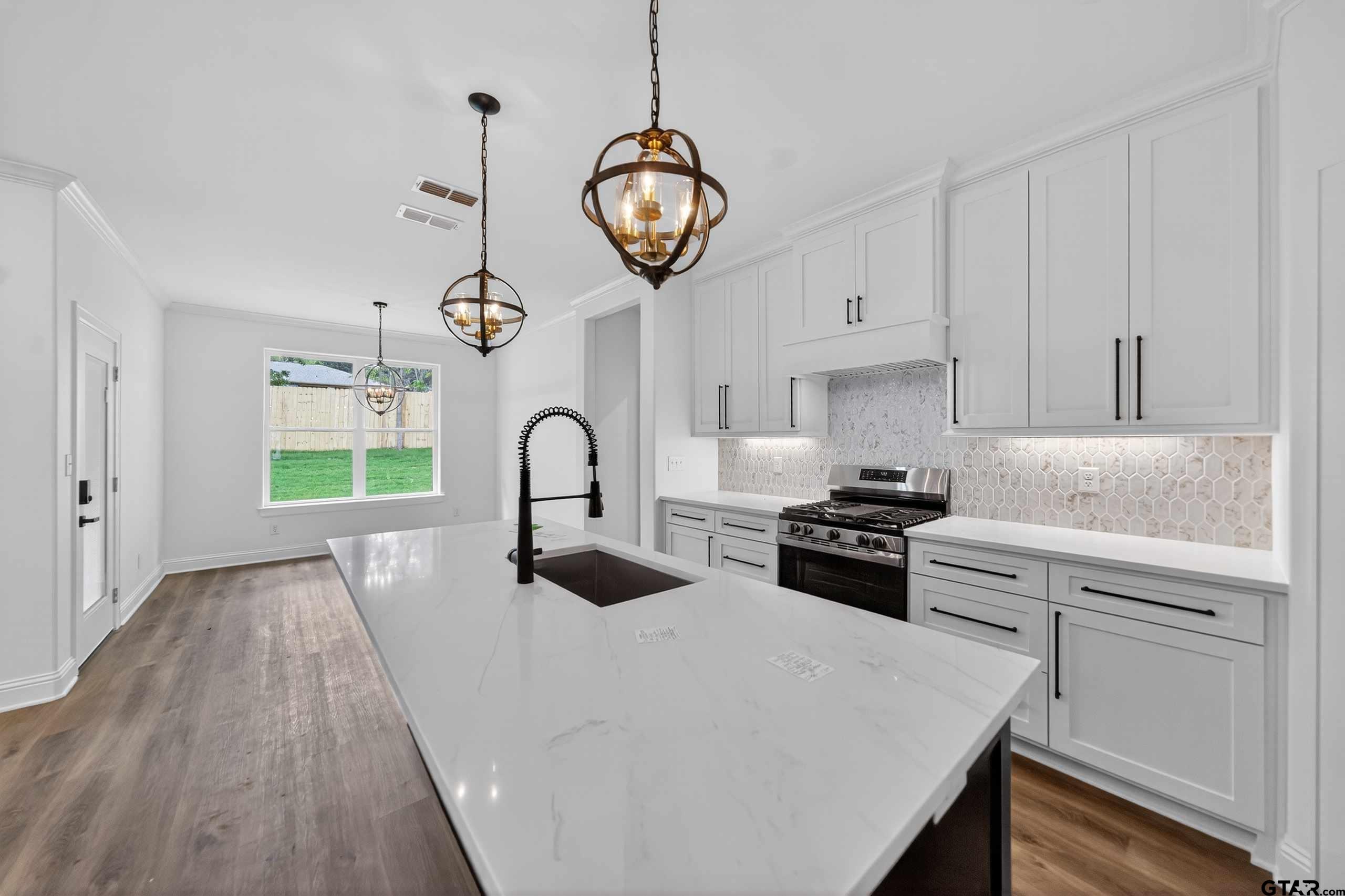 3045 Guinn Farms Road Tyler, TX 75707 - Photo 10 of 45 a kitchen with stainless steel appliances granite countertop a stove a sink and a refrigerator