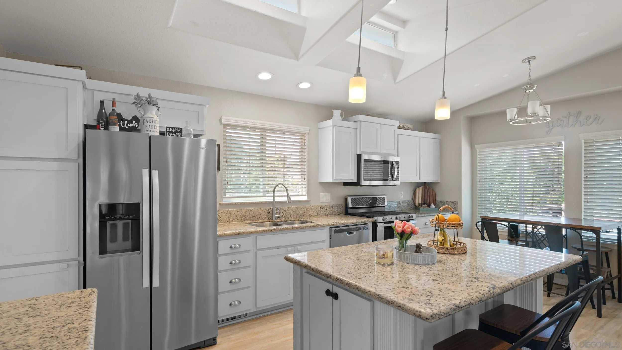 a kitchen with stainless steel appliances granite countertop a sink refrigerator and cabinets