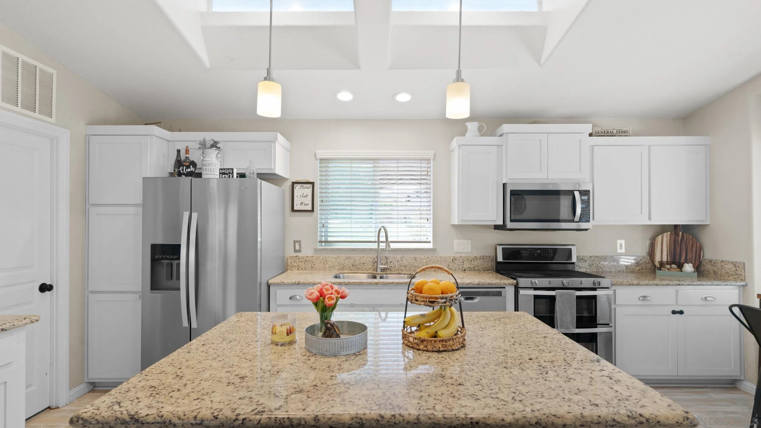 1140 Old Mountain View Road El Cajon, CA 92021 - Photo 2 of 25 a kitchen with a refrigerator a stove a sink dishwasher a dining table and chairs with wooden floor