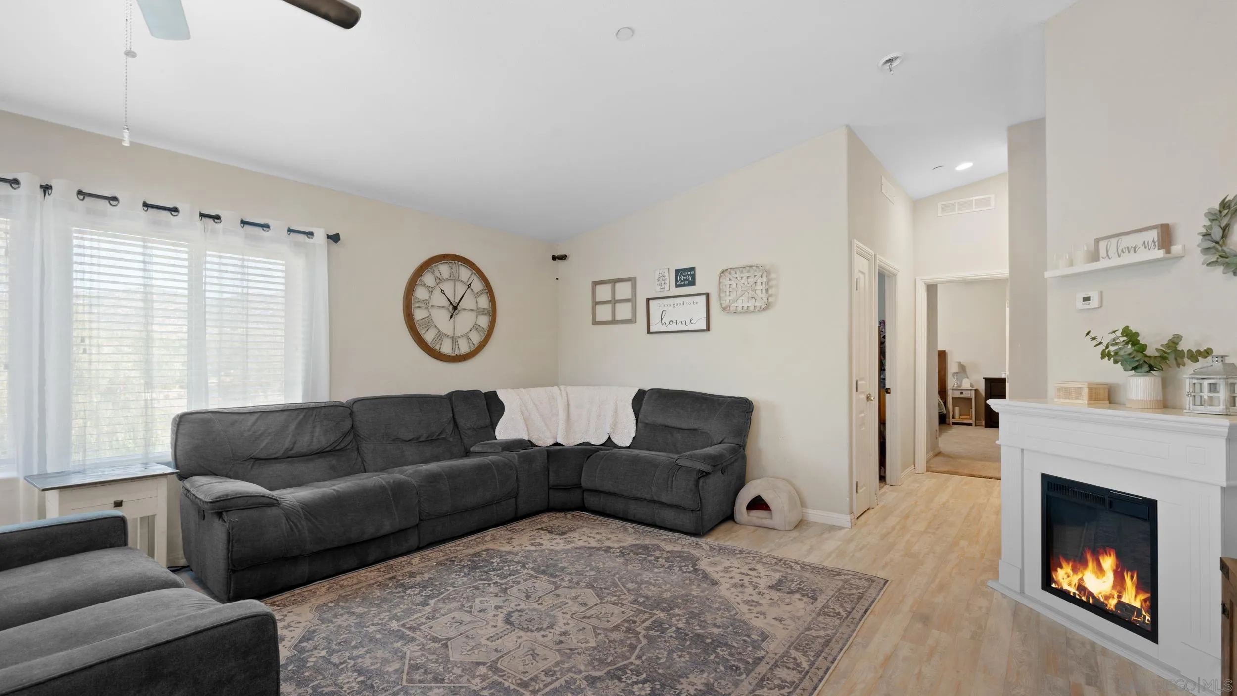 1140 Old Mountain View Road El Cajon, CA 92021 - Photo 8 of 25 a living room with furniture a clock and a fireplace
