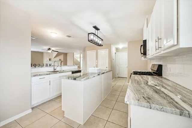 a large kitchen with white cabinets and a stove