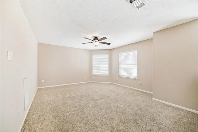 an empty room with a window and a ceiling fan
