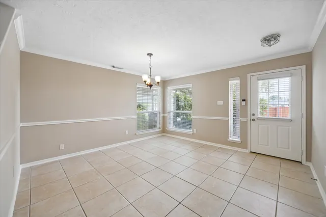 an empty room with windows and chandelier