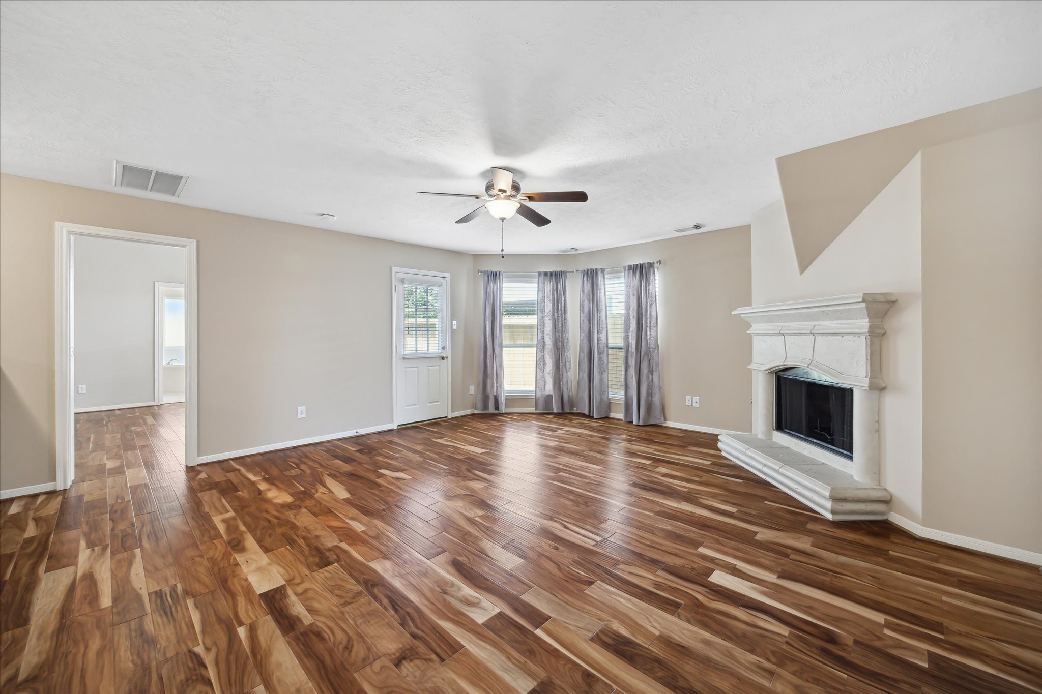 2411 Lacyberry Street Houston, TX 77080 - Photo 4 of 20 a view of an empty room with wooden floor fireplace and a window