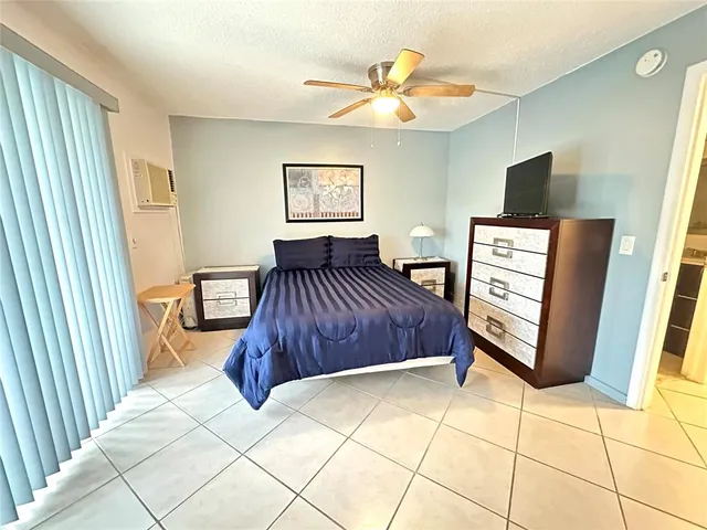 a bedroom with a bed and a tv on the wall