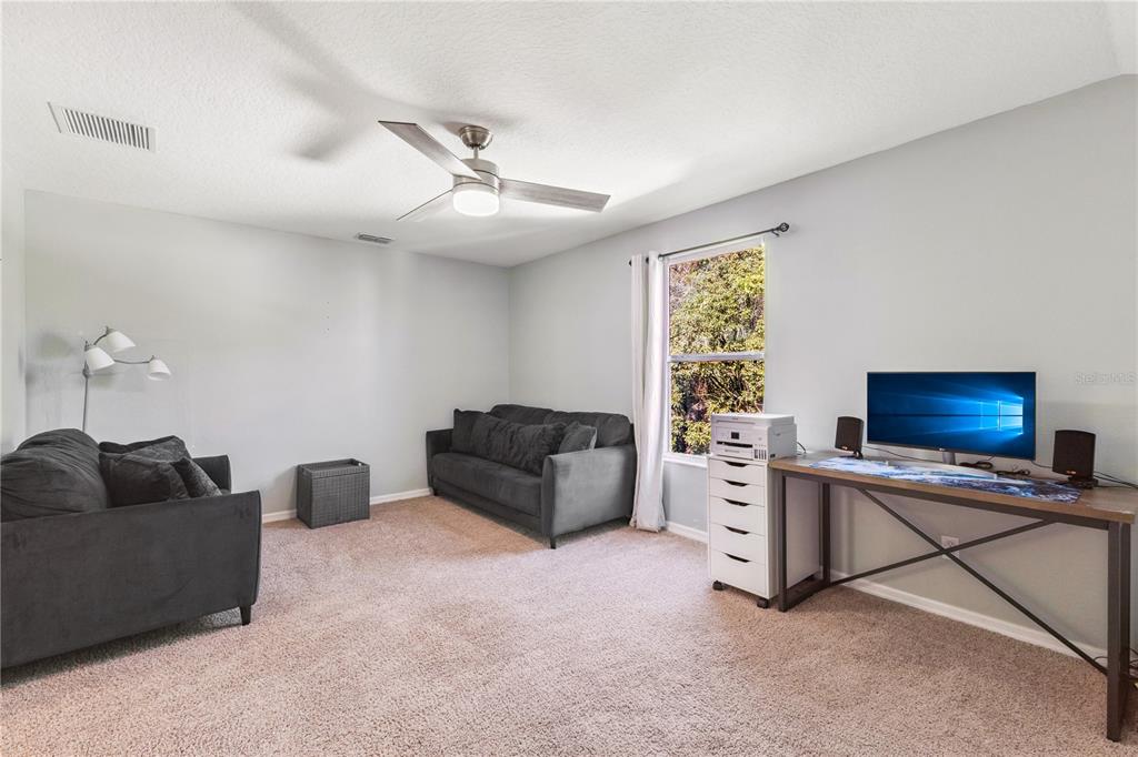 609 Rhodes Drive DeLand, FL 32720 - Photo 23 of 32 a living room with furniture and a flat screen tv
