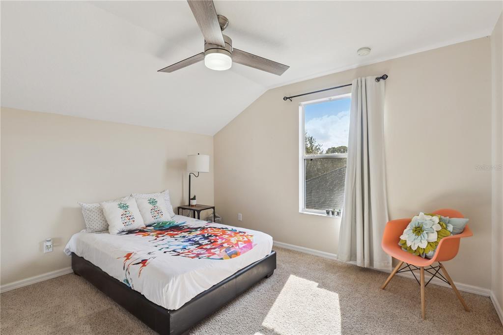 609 Rhodes Drive DeLand, FL 32720 - Photo 24 of 32 a bedroom with a bed and a chandelier