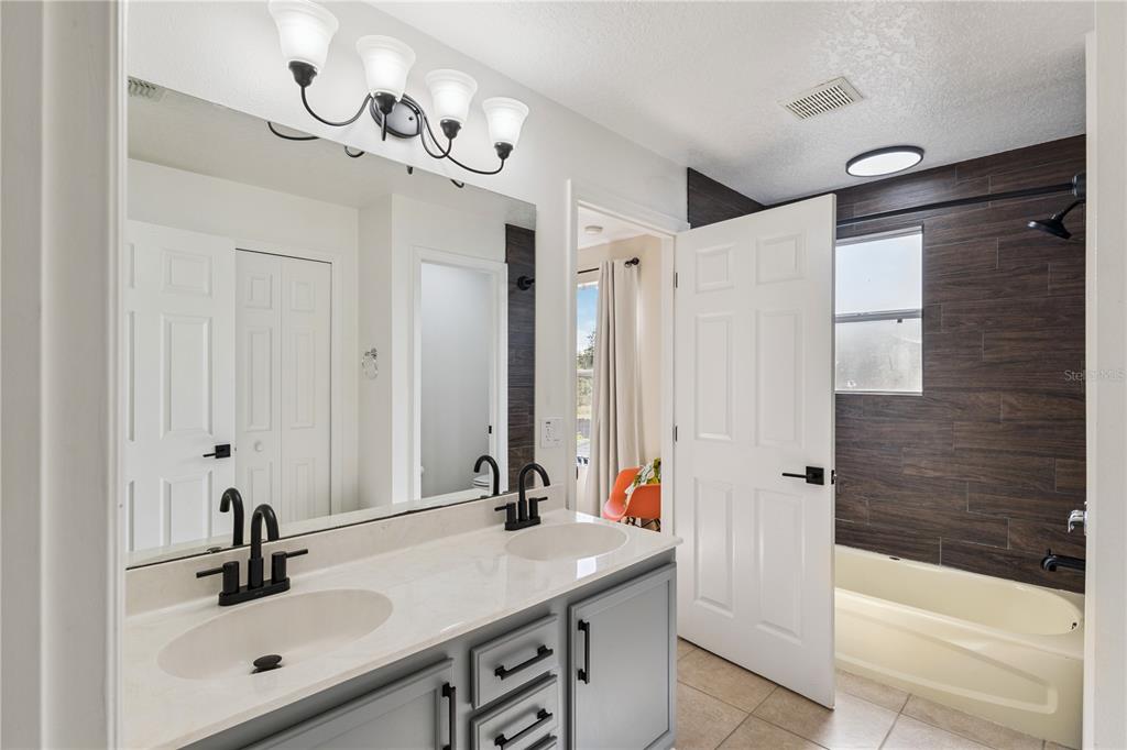 609 Rhodes Drive DeLand, FL 32720 - Photo 25 of 32 a bathroom with a sink vanity granite tub shower and mirror