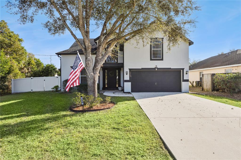 609 Rhodes Drive DeLand, FL 32720 - Photo 3 of 32 a front view of a house with a yard and garage