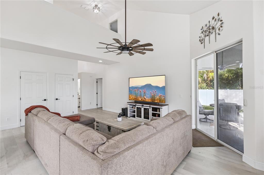 609 Rhodes Drive DeLand, FL 32720 - Photo 6 of 32 a living room with furniture and a flat screen tv with kitchen view