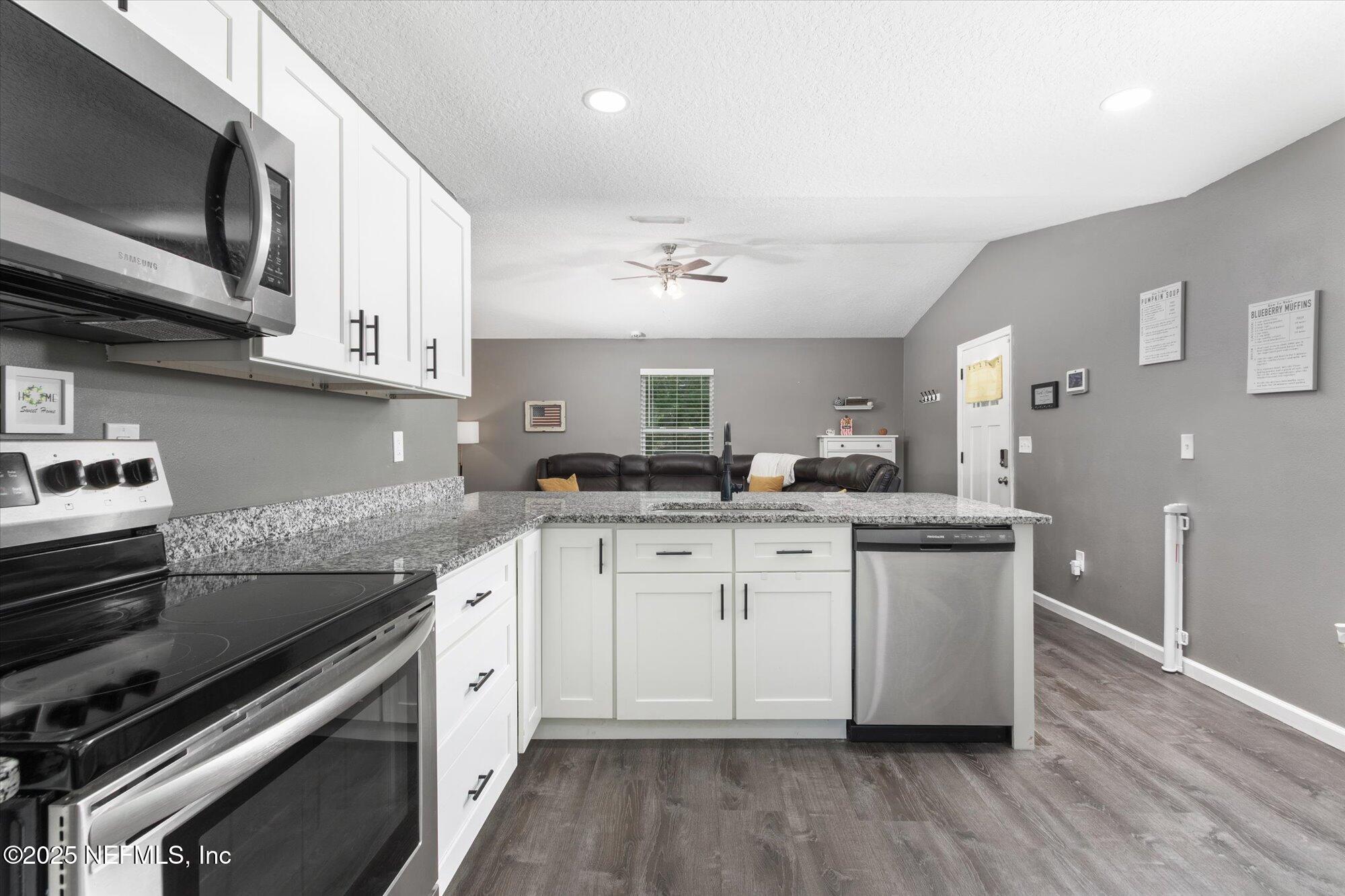 3615 Weaver Road Palatka, FL 32177 - Photo 8 of 30 a kitchen with stainless steel appliances granite countertop a sink a stove a microwave and cabinets