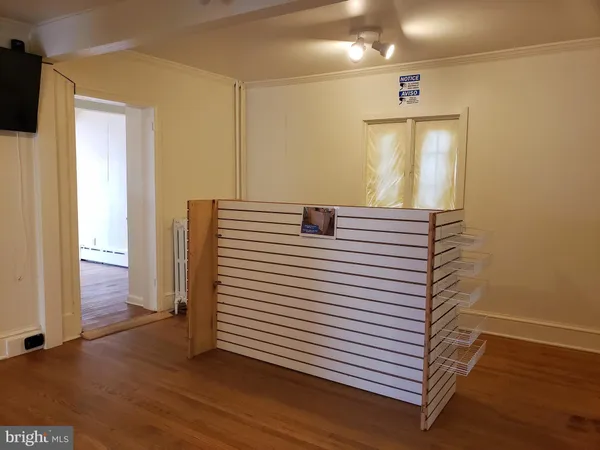 a view of a hallway with entryway and wooden floor