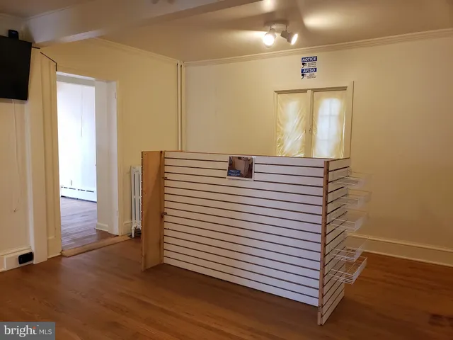 a view of a hallway with entryway and wooden floor