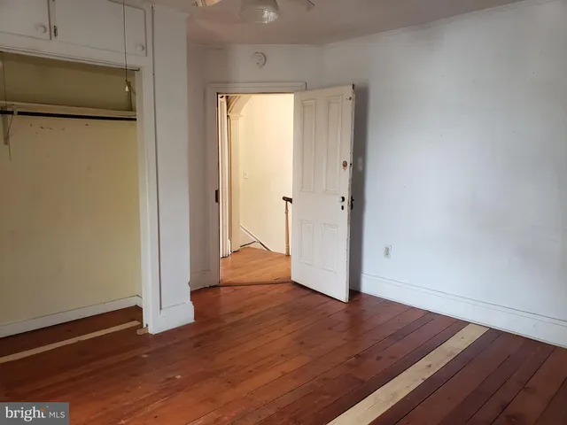 an empty room with wooden floor and a window