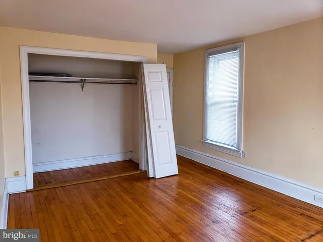 an empty room with wooden floor and closet