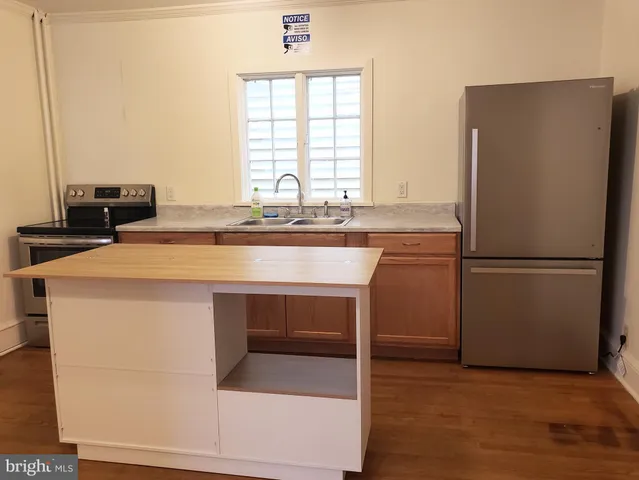 a kitchen with kitchen island a stove a sink and a refrigerator