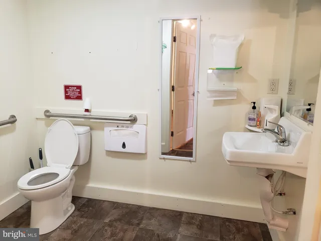 a bathroom with a sink toilet and a mirror