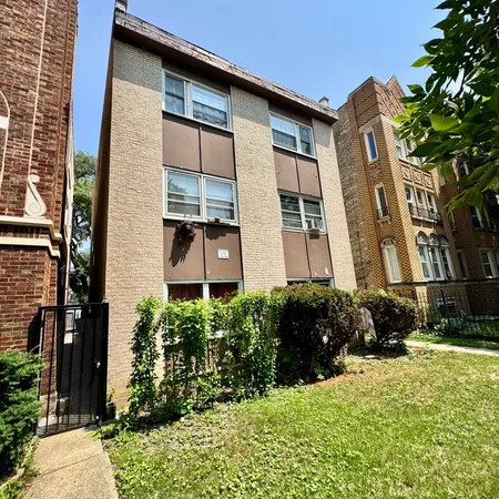 a couple of potted plants in front of a brick house