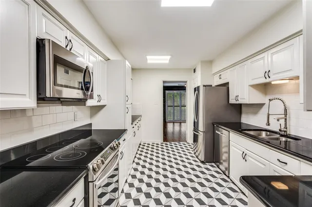 a kitchen with stainless steel appliances a sink stove and refrigerator