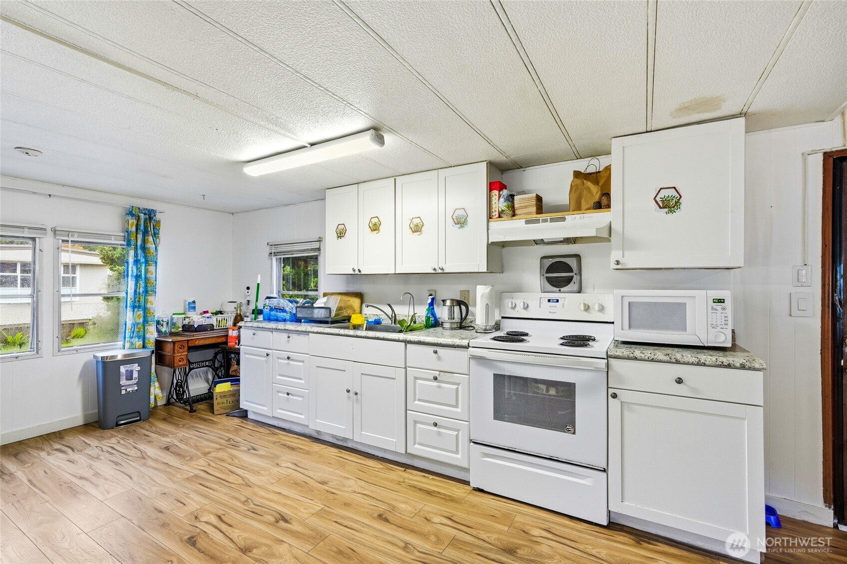 11330 East Riverside Drive, Unit 25 Bothell, WA 98011 - Photo 9 of 19 a kitchen with cabinets wooden floor and stainless steel appliances