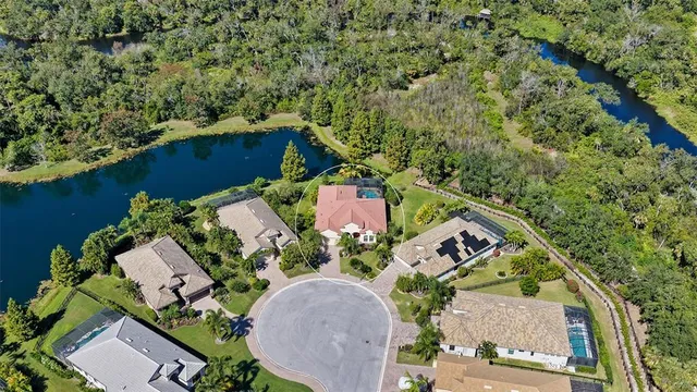 an aerial view of a house with a yard and lake view